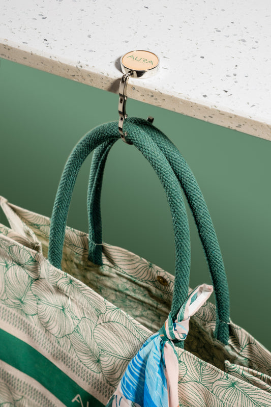 AURA Bag Hanger unfolded, holding tote bag handles from a countertop edge