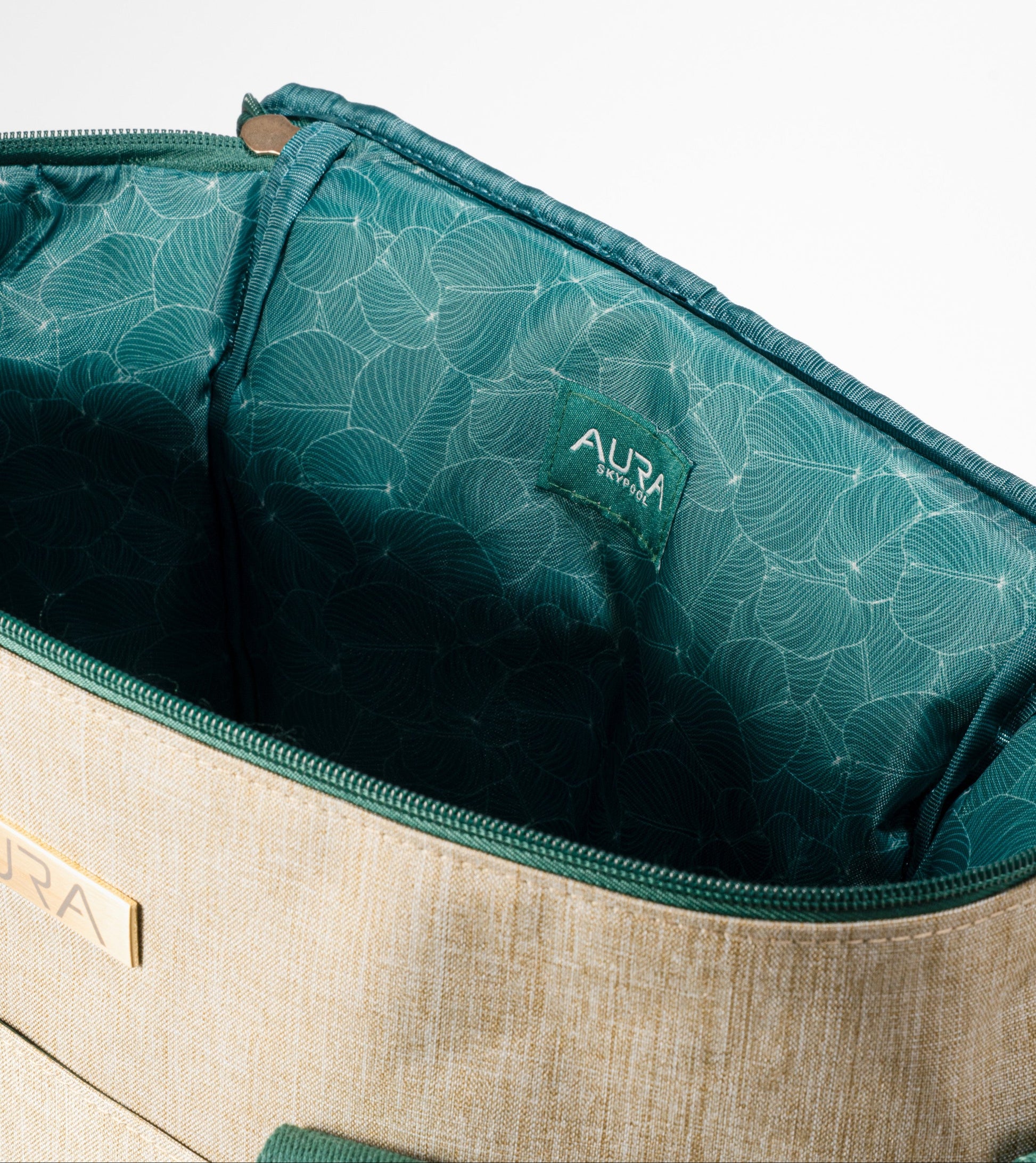 Interior of AURA Cooler Bag with green leaf-print lining and AURA Skypool logo tab