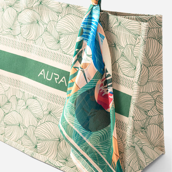 Close-up of AURA Signature Tote Bag corner with green padded handle and scarf styling detail