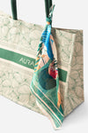 Close-up of AURA Signature Tote Bag corner with green padded handle and scarf styling detail