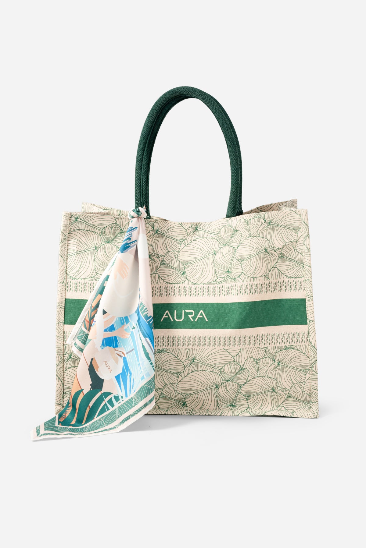 Angled front view of AURA Signature Tote Bag showing green leaf print and AURA logo band