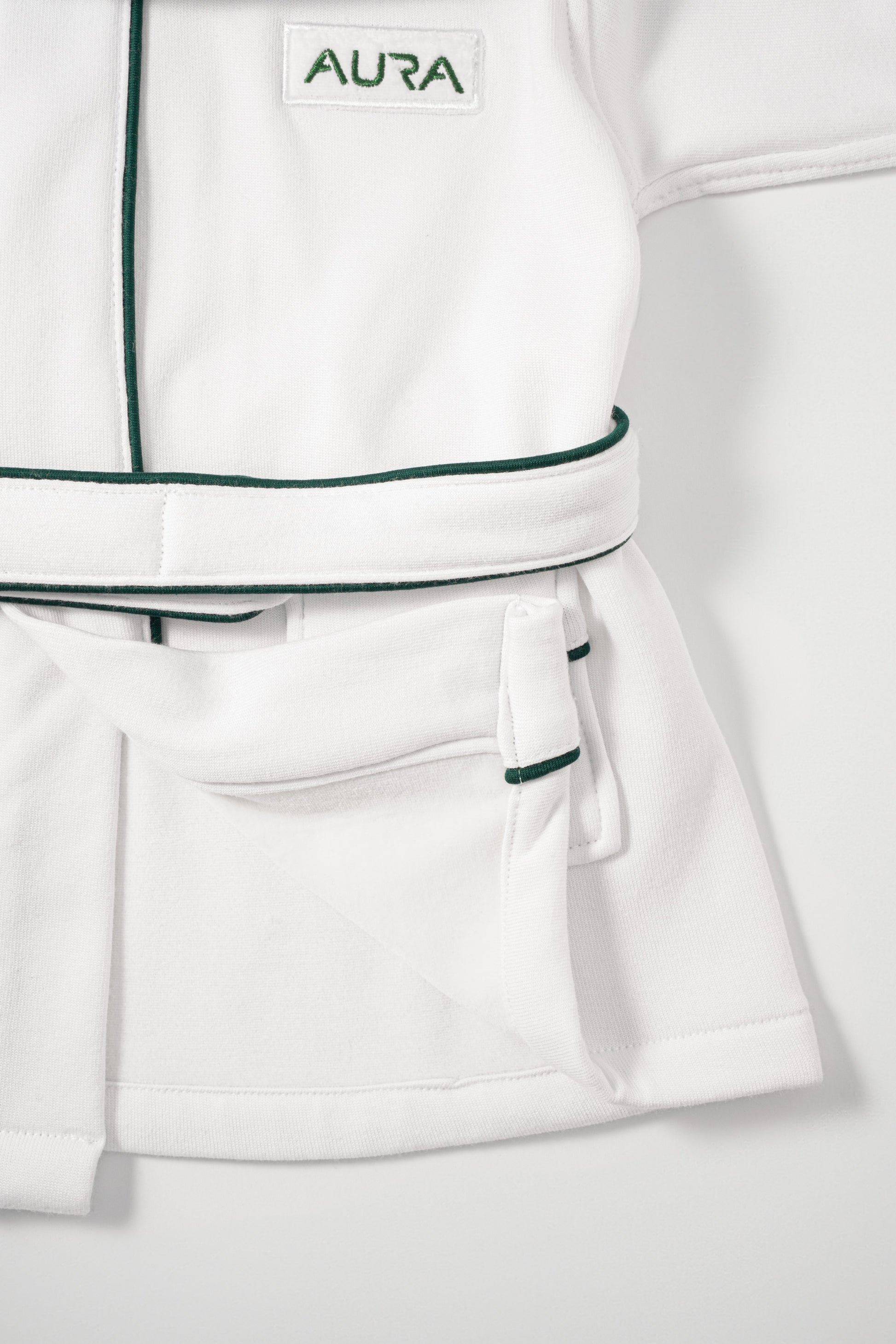 AURA woven label and green piping detail on baby bathrobe pocket