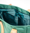 Open interior of AURA Beach Bag Palm Green showing teal leaf-print lining and slip pockets