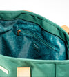 Interior zip pocket detail of AURA Beach Bag Palm Green with teal leaf-print lining