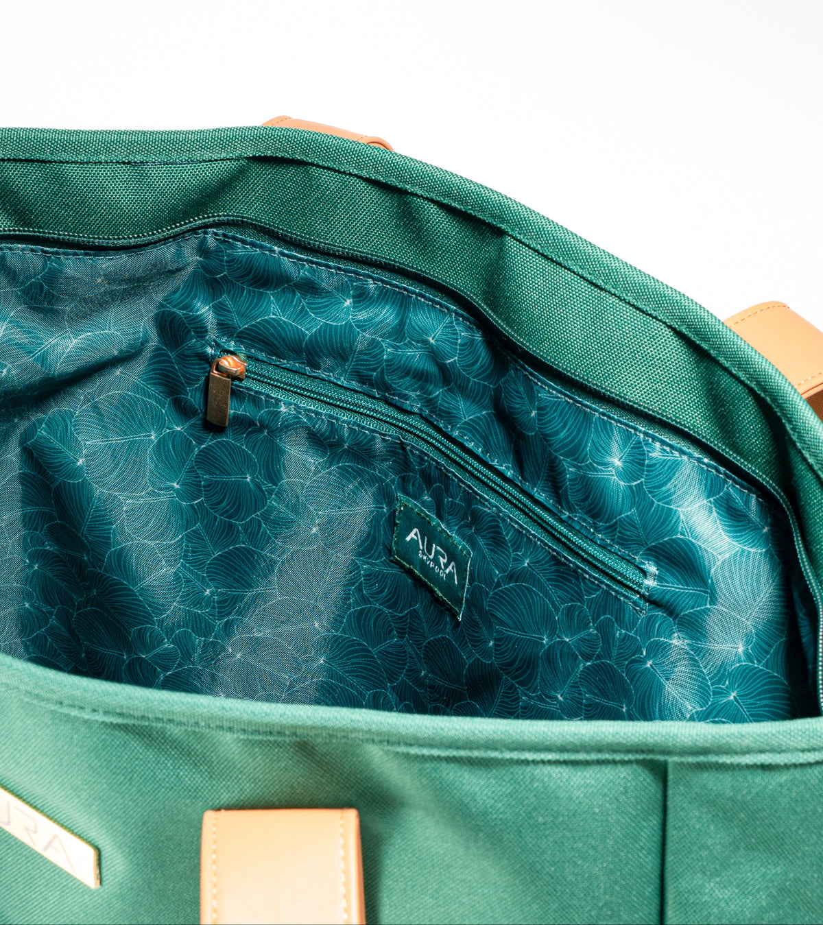 Interior zip pocket detail of AURA Beach Bag Palm Green with teal leaf-print lining