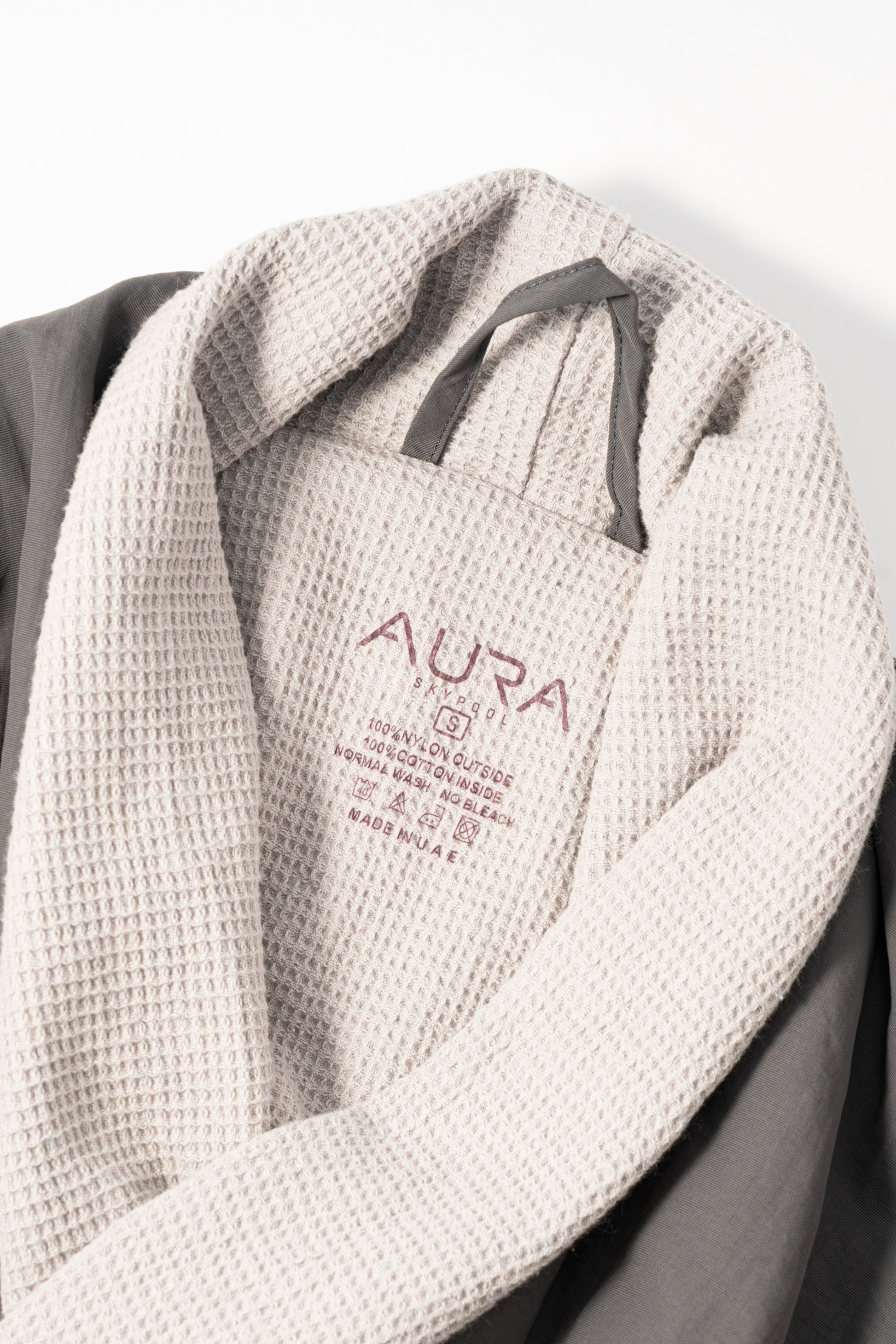 AURA Skypool care label on Cosy Robe, 100% nylon outside, 100% cotton inside, made in UAE