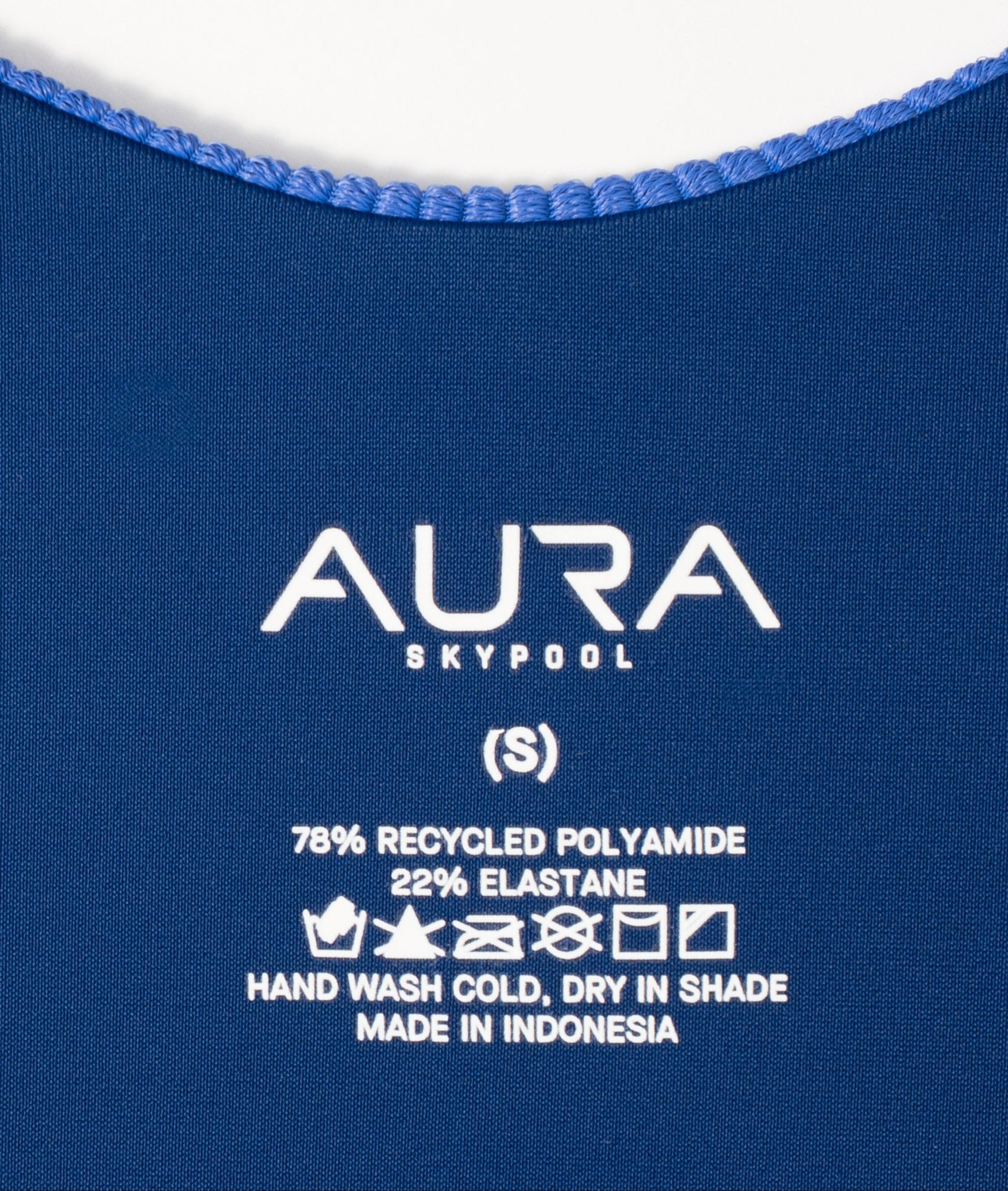 AURA care label on Cote d'AURA swimsuit, 78% recycled polyamide 22% elastane, made in Indonesia