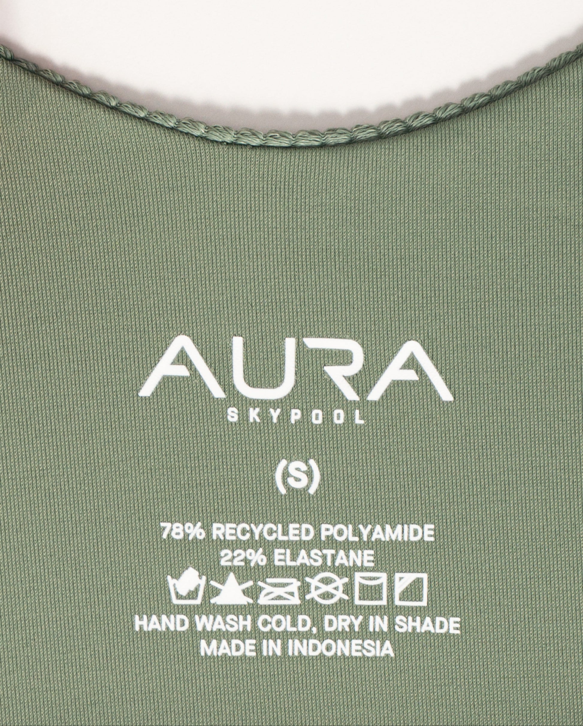 AURA care label on Cote d'AURA swimsuit, 78% recycled polyamide 22% elastane, made in Indonesia