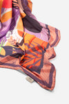 Dubai Skyline Sarong in coral, draped close-up showing silk print and AURA label
