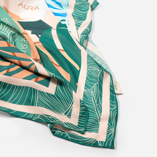 Dubai Skyline Sarong in green, draped close-up showing silk print and AURA label