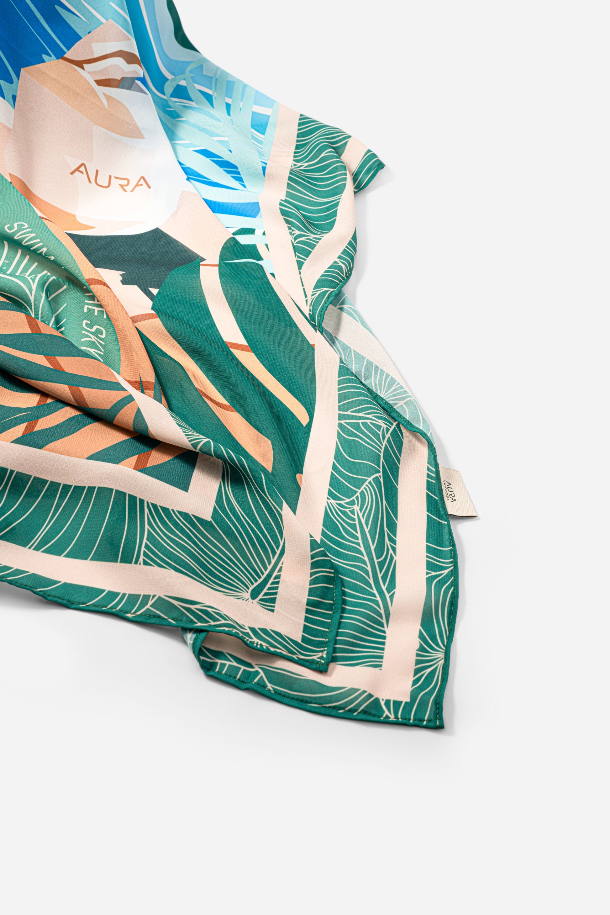 Dubai Skyline Sarong in green, draped close-up showing silk print and AURA label