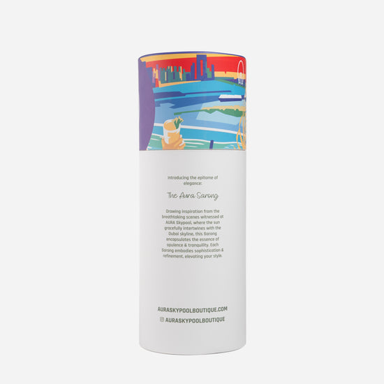 Dubai Skyline Sarong in indigo, tube packaging back reading 'The AURA Sarong' with brand story text