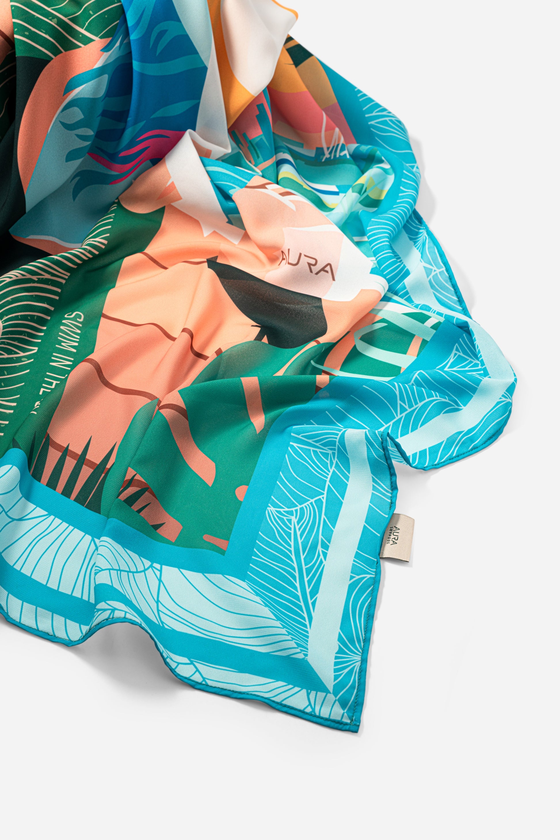 Dubai Skyline Sarong in sky blue, draped close-up showing silk print and AURA label
