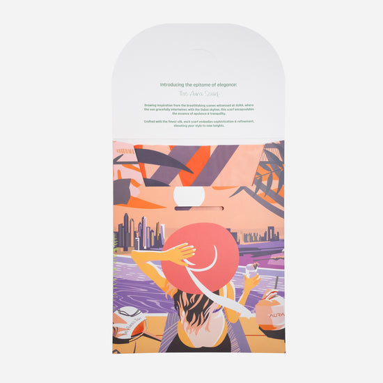 Dubai Skyline Silk Scarf in Coral, packaging card with AURA scarf description