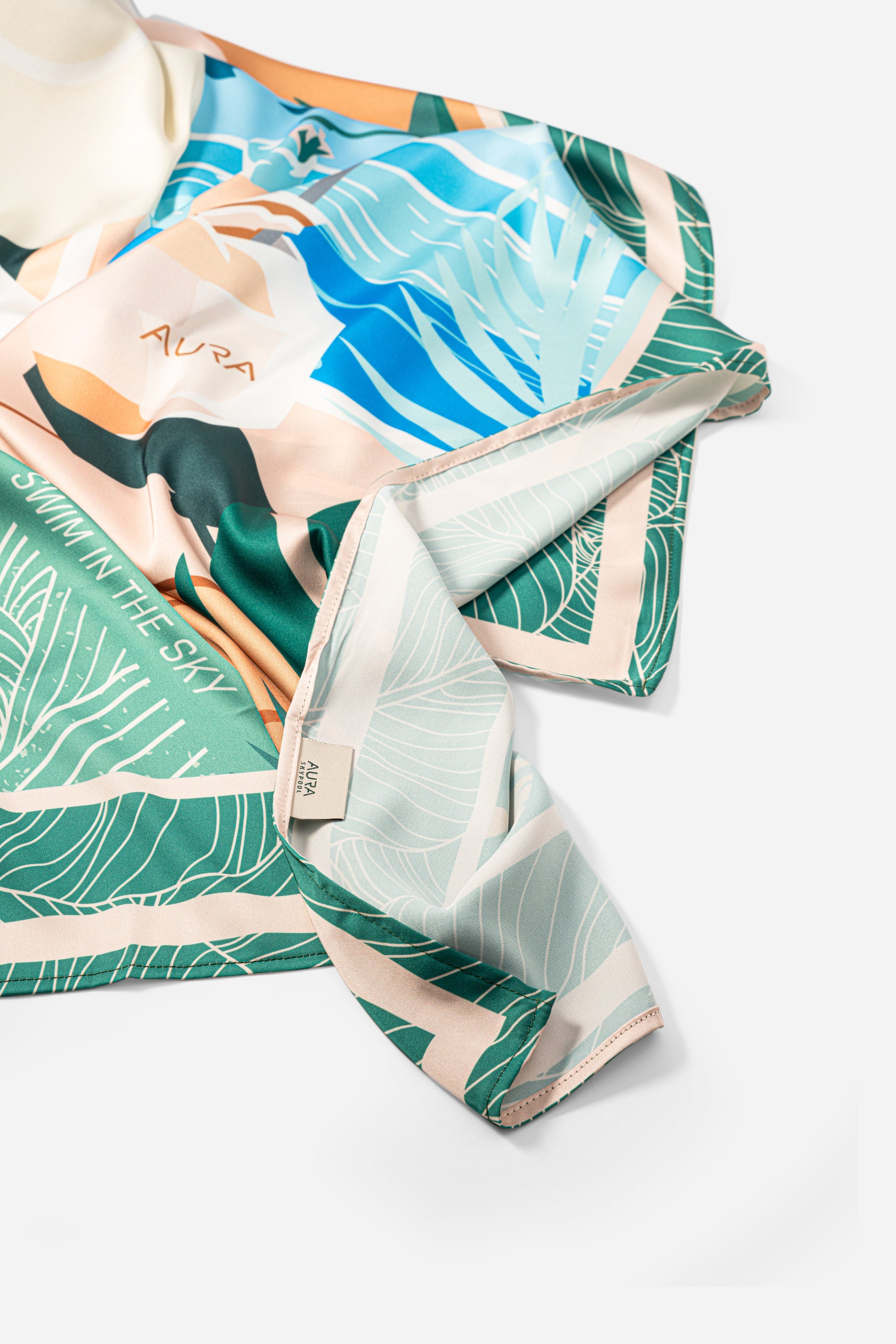 Dubai Skyline Silk Scarf in Green, draped showing the mint reverse border print