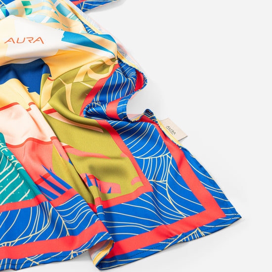 Dubai Skyline Silk Scarf in Indigo, draped close-up showing the AURA woven label