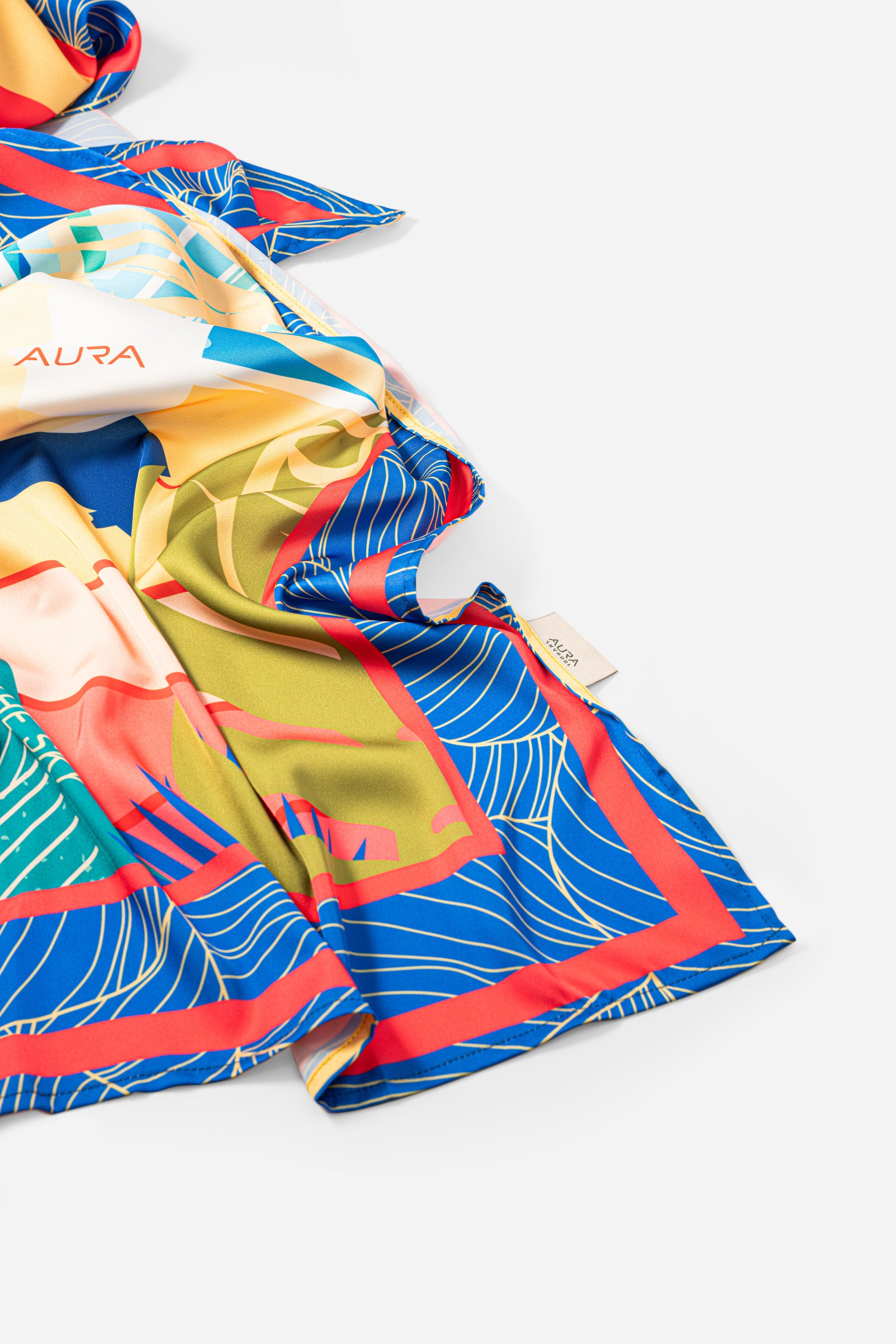 Dubai Skyline Silk Scarf in Indigo, draped close-up showing the AURA woven label