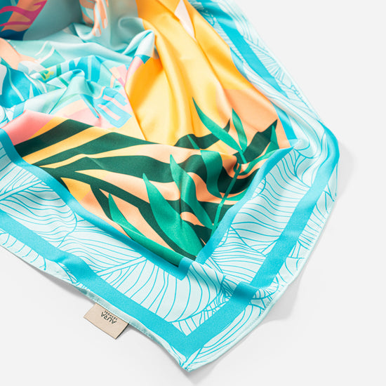 Dubai Skyline Silk Scarf in Sky Blue, draped close-up showing the AURA woven label