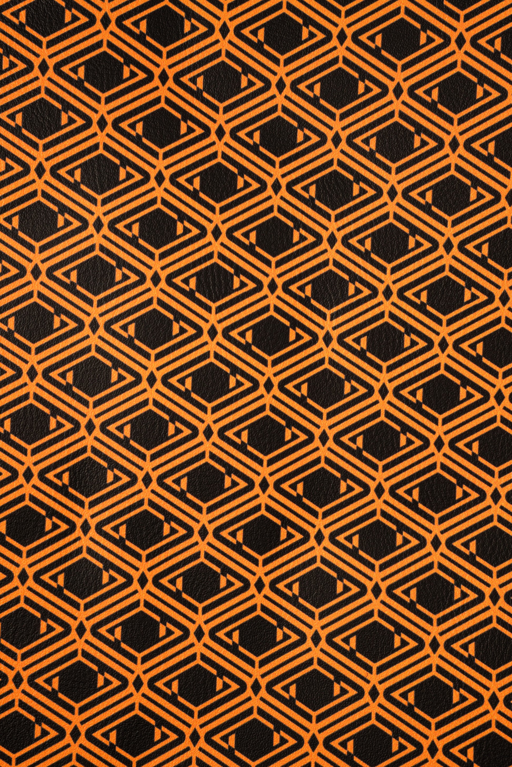 AURA Laptop Sleeve close-up of the orange and black monogram print pattern