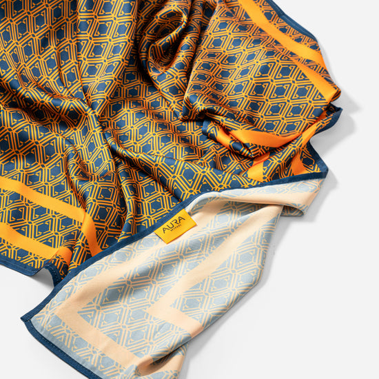 Monogram Silk Scarf in Midnight Mirage, bunched showing the AURA label and pale reverse