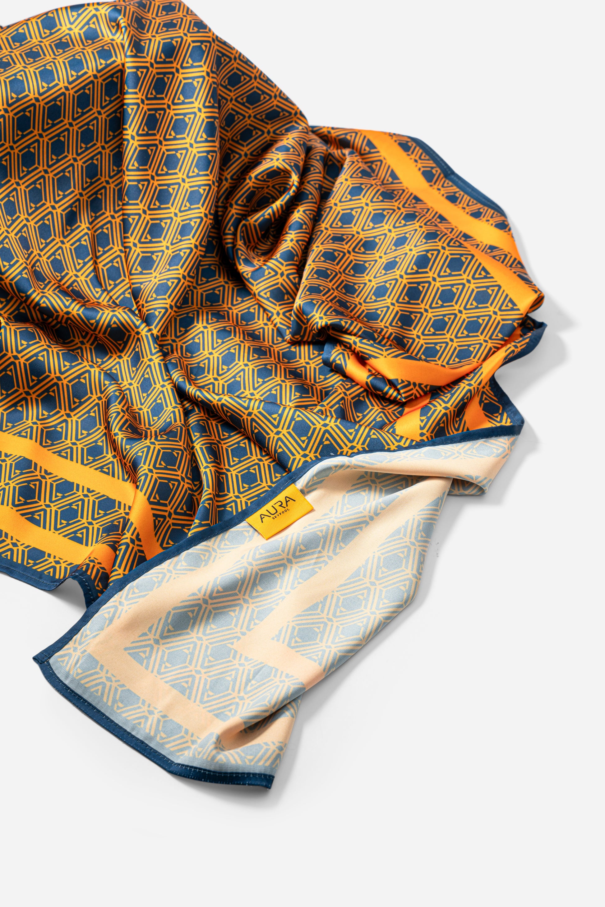 Monogram Silk Scarf in Midnight Mirage, bunched showing the AURA label and pale reverse