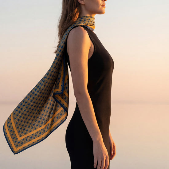 AURA Monogram Silk Scarf in Midnight Mirage, worn draped over one shoulder