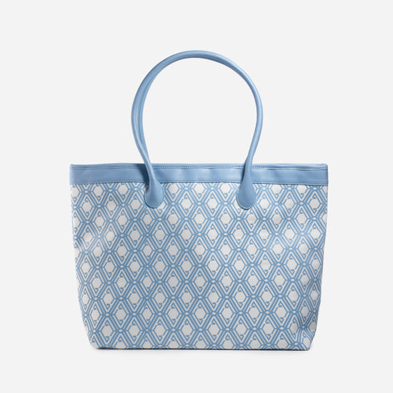 Front view of The Monogram Bag in Azure Blue with white and sky-blue geometric print and blue handles
