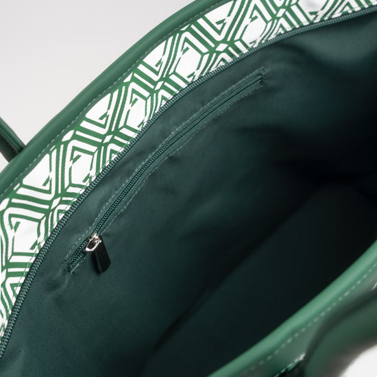Open interior of The Monogram Bag Evergreen showing dark green satin lining and zip pocket