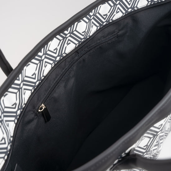 Open interior of The Monogram Bag Night Black showing black satin lining and gold-tone zip pocket