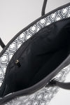Open interior of The Monogram Bag Night Black showing black satin lining and gold-tone zip pocket