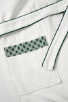 Waffle Robe pocket detail showing evergreen AURA monogram print trim