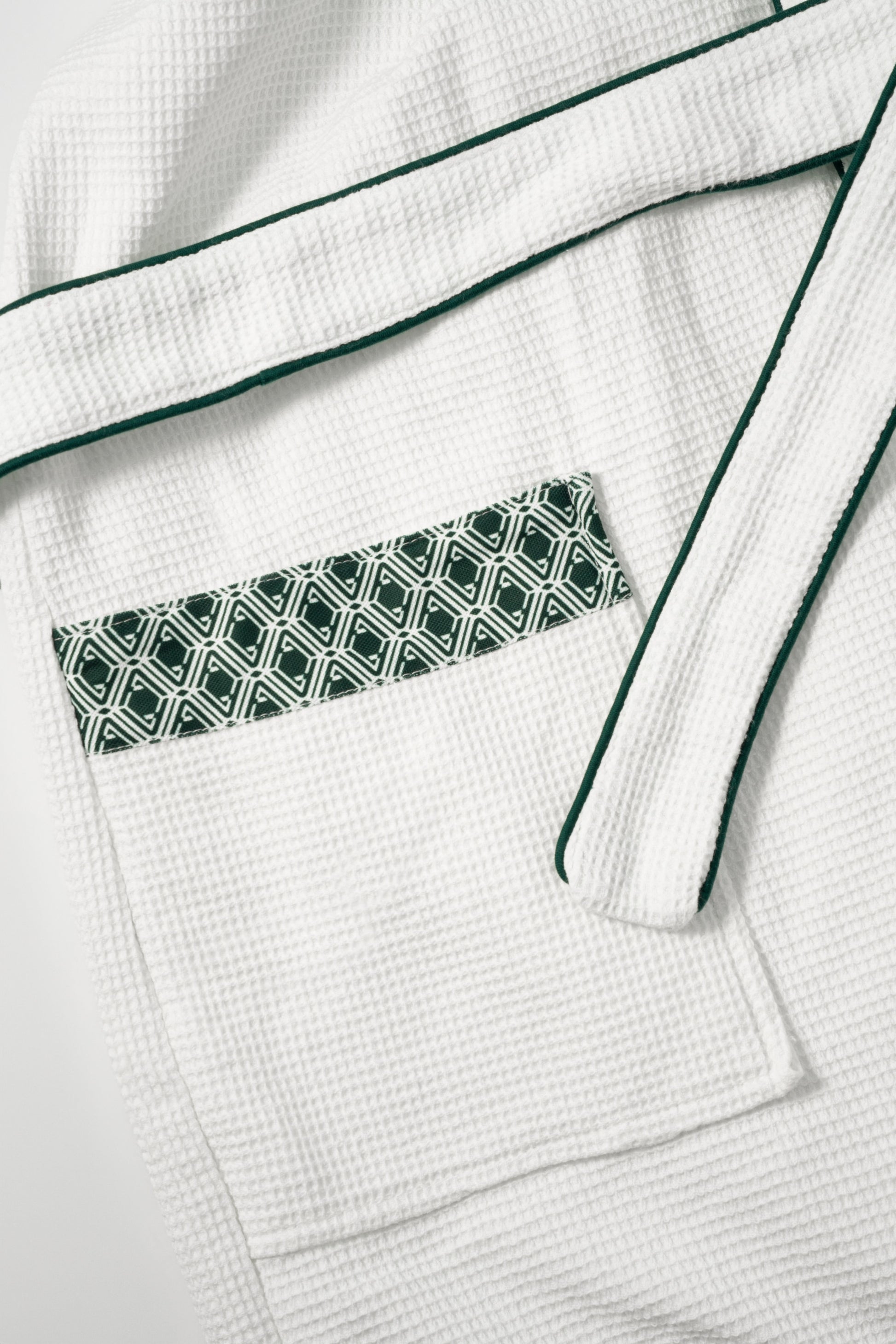 Waffle Robe pocket detail showing evergreen AURA monogram print trim