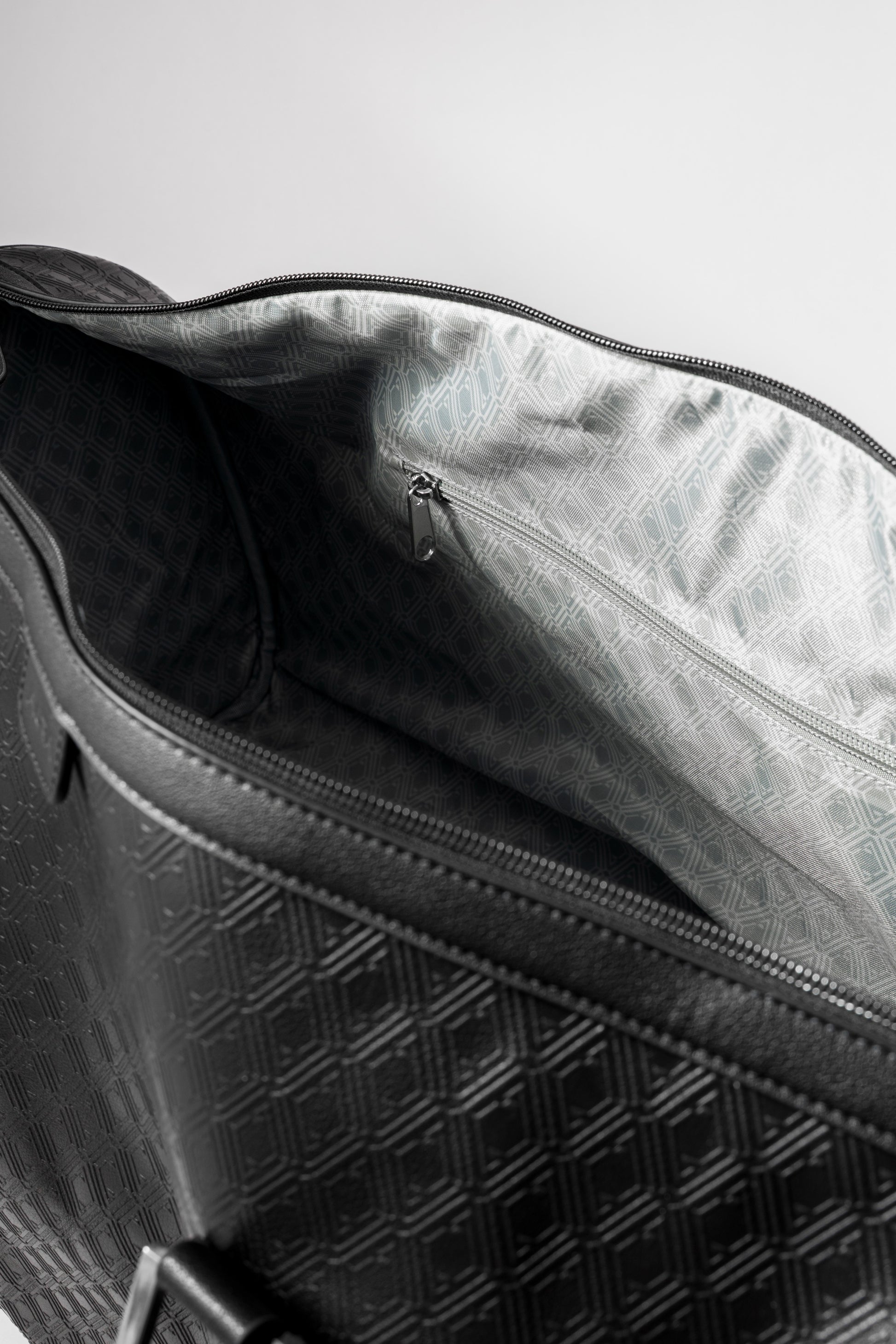 Pinnacle Duffle monogram black interior showing silver geometric-print lining