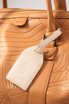 Weekender Duffle clay luggage tag and embossed AURA logo detail