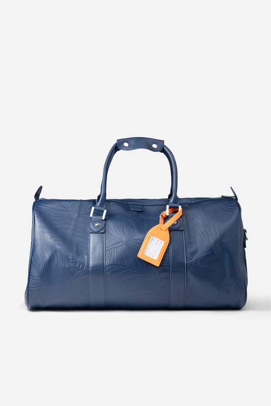 AURA Weekender Duffle in horizon blue with leaf-embossed leather and orange luggage tag