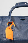 Weekender Duffle horizon blue handle and orange AURA luggage tag detail