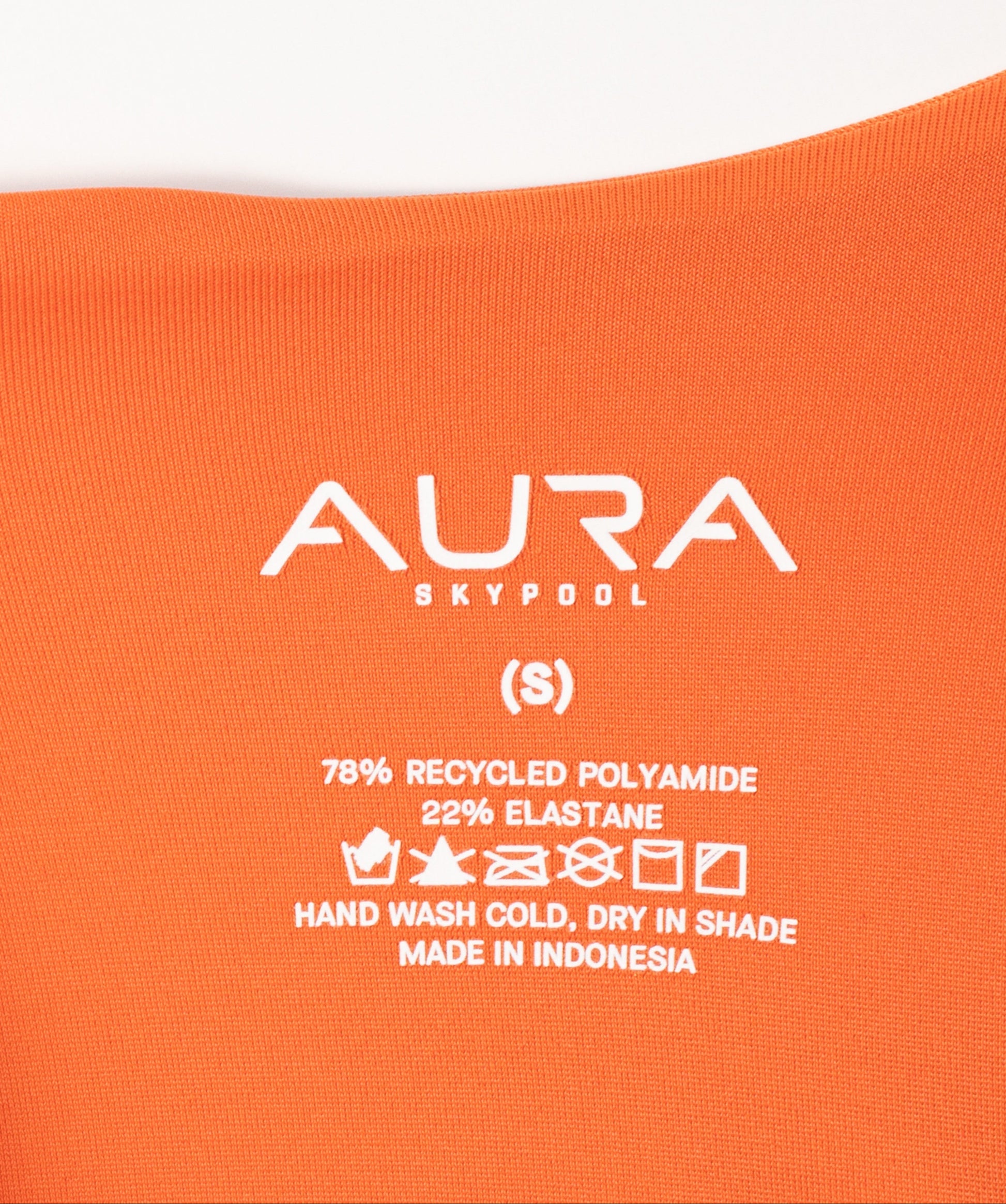 AURA care label on Velora swimsuit, 78% recycled polyamide 22% elastane, made in Indonesia