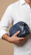 Model carrying AURA wash bag in horizon blue leaf-embossed leather